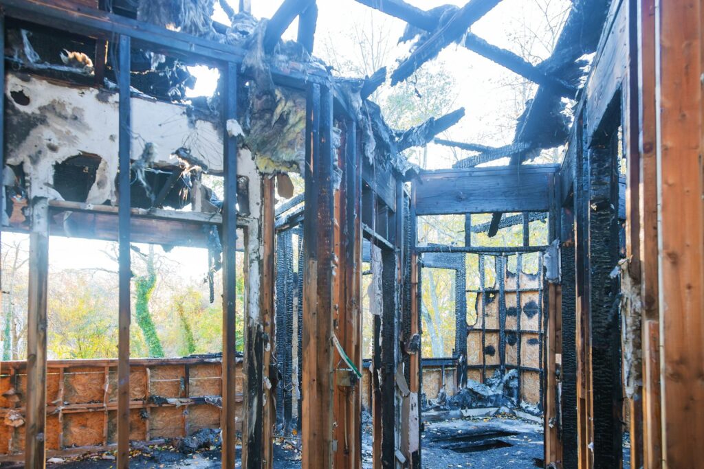 Burned wooden wall home after fire and burned everything in the area.