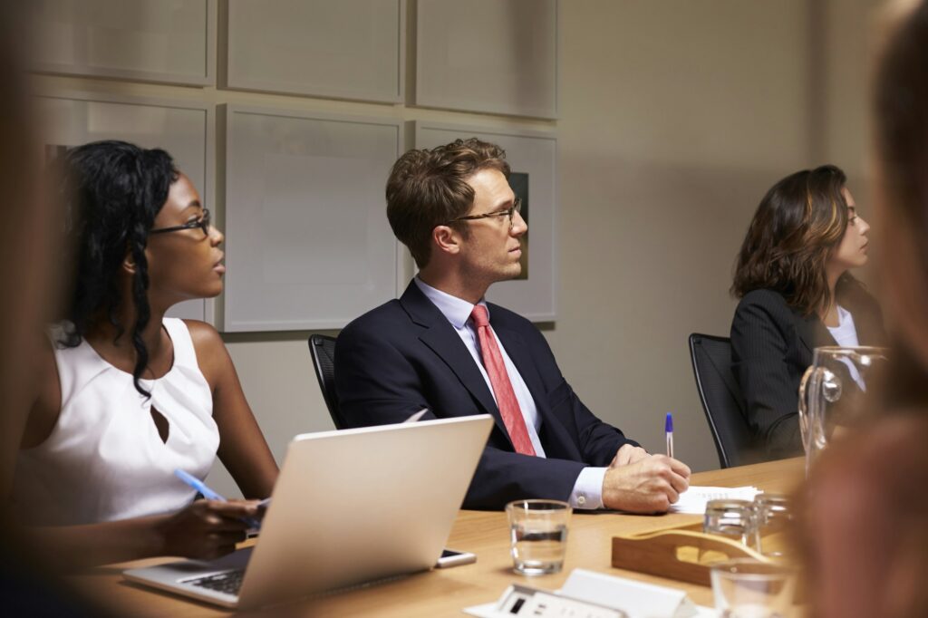 Business colleagues listening at boardroom meeting